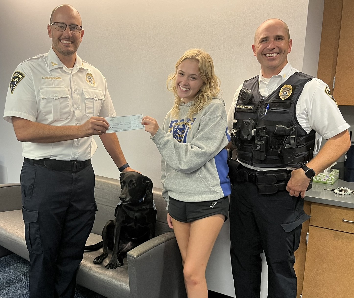 Chief Kirk Brueggeman presenting Emma Matevey with her scholarship check.