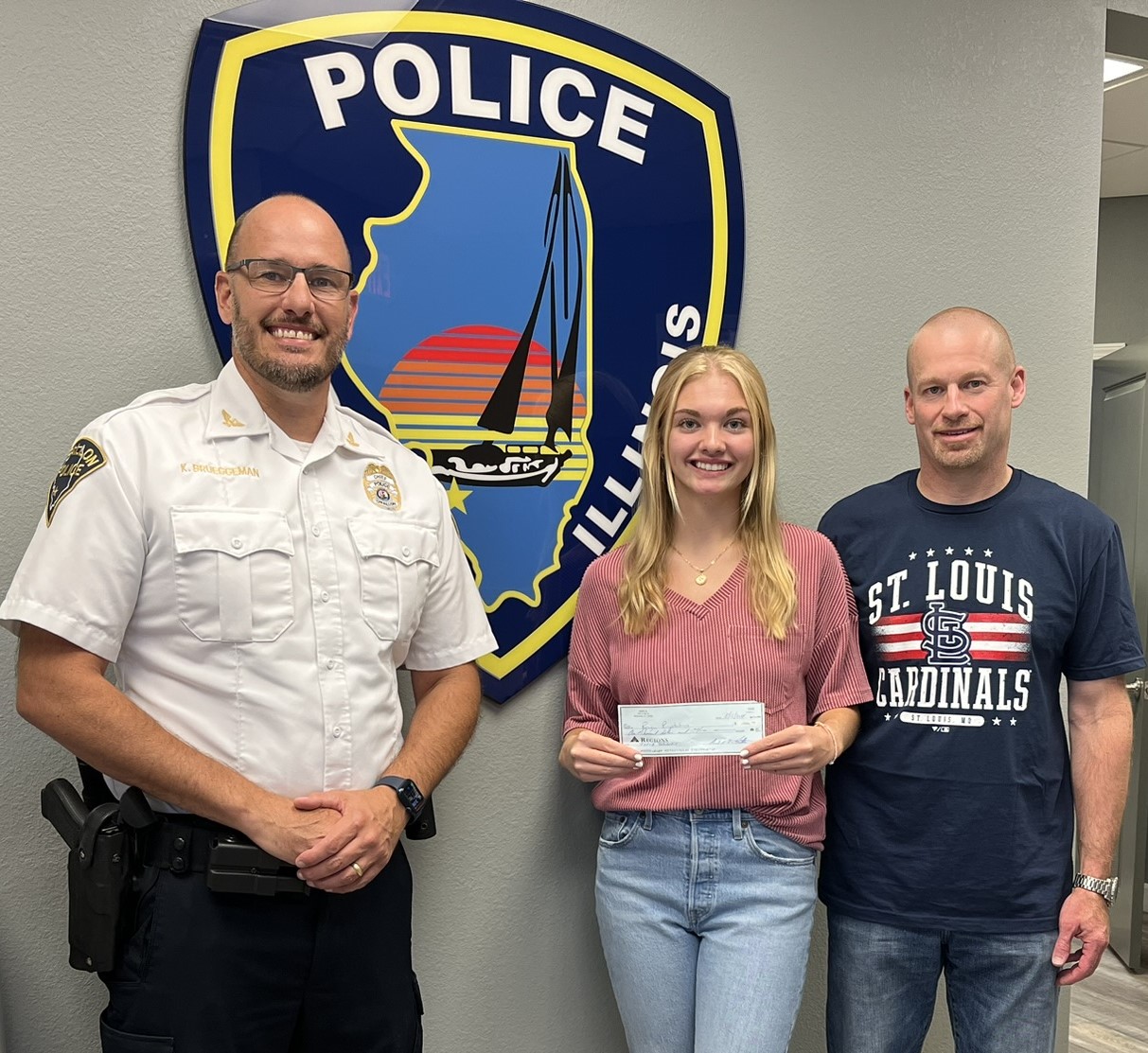 Chief Kirk Brueggeman presenting Reagan Pingsterhaus her scholarship check.